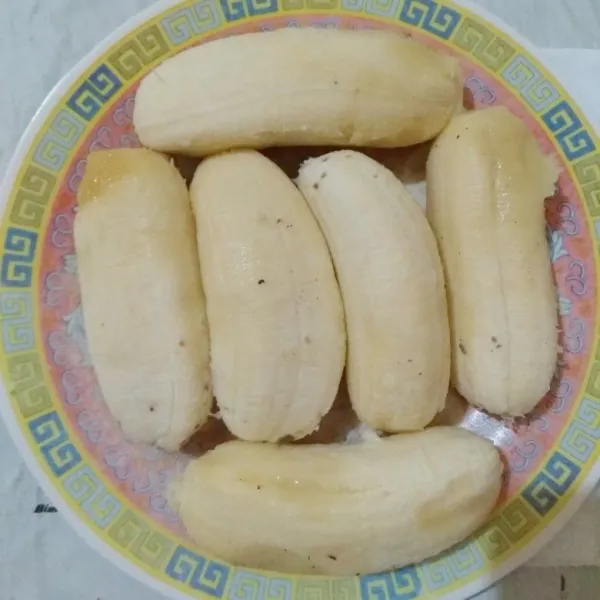 Kupas pisang kepok, belah menjadi 2 bagian.