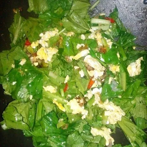 Masukkan sawi dan telur lalu ratakan.