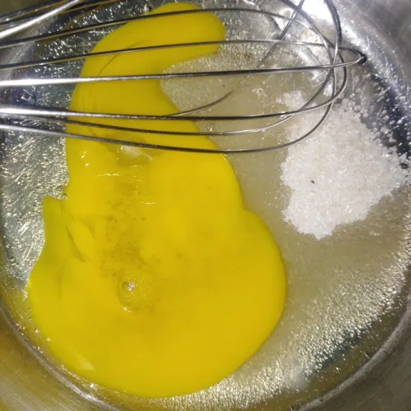 Kocok gula dan telur menggunakan whisk hingga rata.