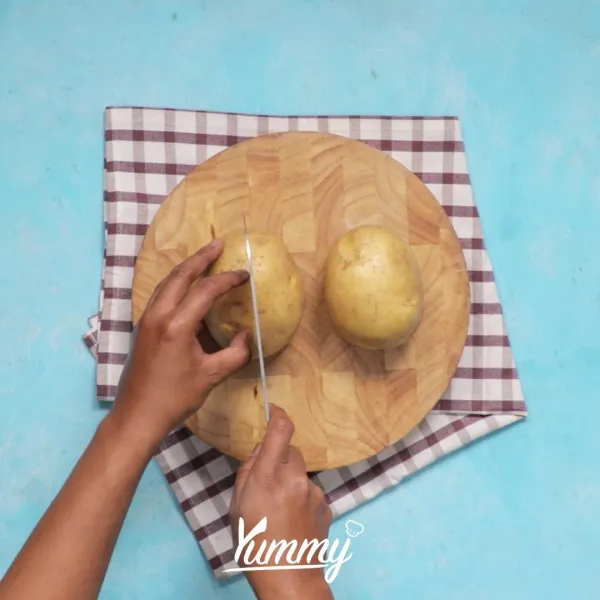Rebus kentang dengan air hingga matang. Setelah matang angkat lalu iris menjadi dua lalu kerok bagian tengahnya. Sisihkan bagian tengah kentang dan kulit kentang.