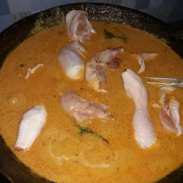 Lalu masukkan ayam, asam cekala, gula merah, dan juga garam. Masak hingga santannya menyusut dan agak mengental.