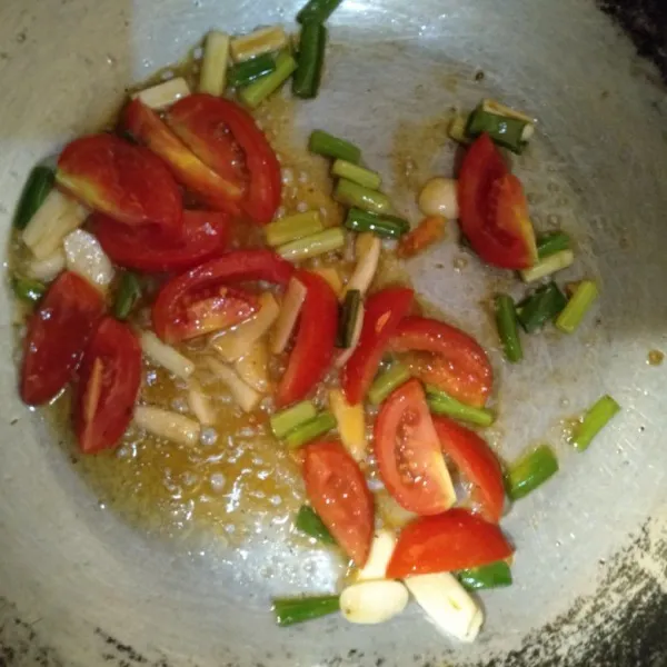 Kemudian, tumis bawang daun dan tomat terlebih dahulu.