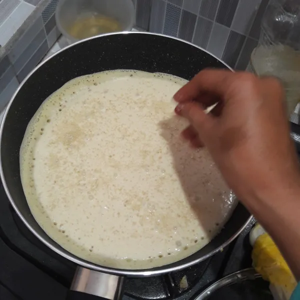 Taburkan gula pasir, masak dengan menutup wajan teflon hingga permukaan martabak matang. Angkat.