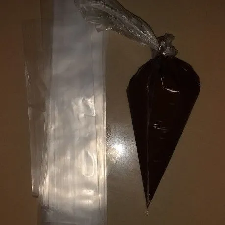 Siapkan piping bag dan plastik es mambo, lalu tuang coklat leleh ke dalam piping bag, gunting bagian ujung piping bag.