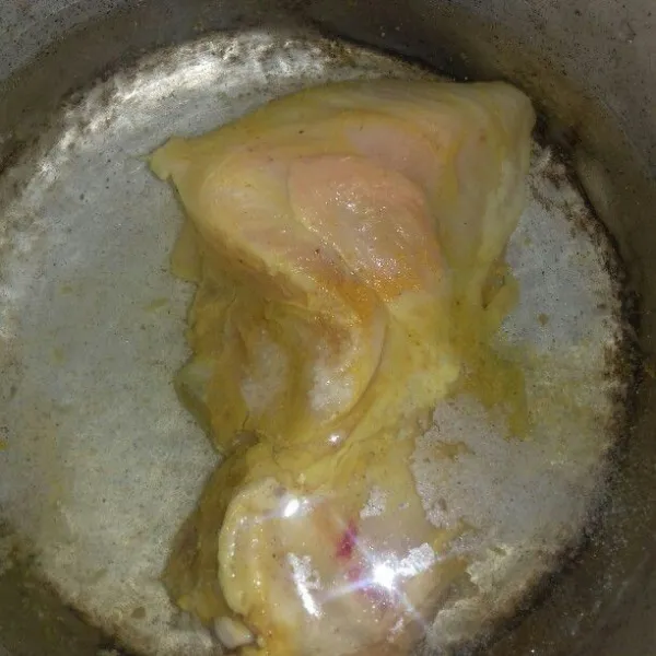 Rebus setengah matang dada ayam yang sudah dibaluri kunyit bubuk dan garam.