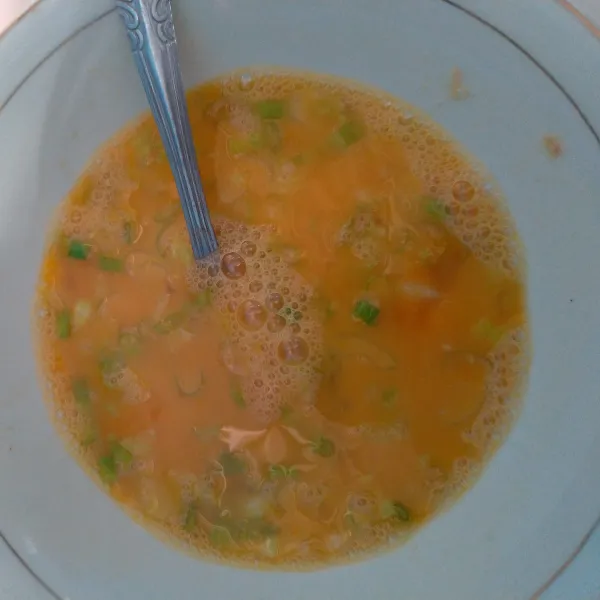 Aduk-aduk butir telur, beri garam dan irisan daun bawang.