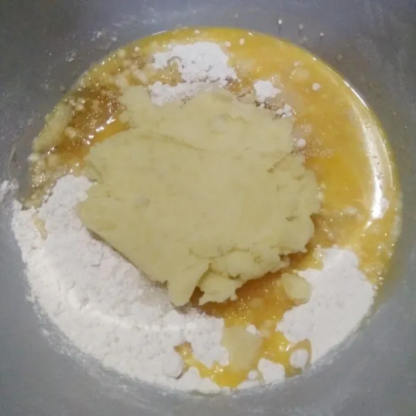 Masukkan tepung terigu, kuning telur, kentang kukus yang dihaluskan, gula pasir, ragi instan, dan air dingin ke dalam mangkok. Mixer hingga adonan tercampur rata.