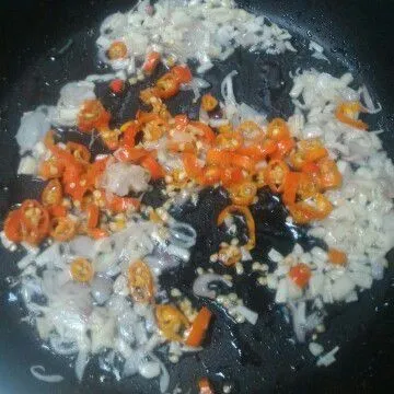 Tumis bawang merah, bawang putih dan cabai iris hingga layu.
