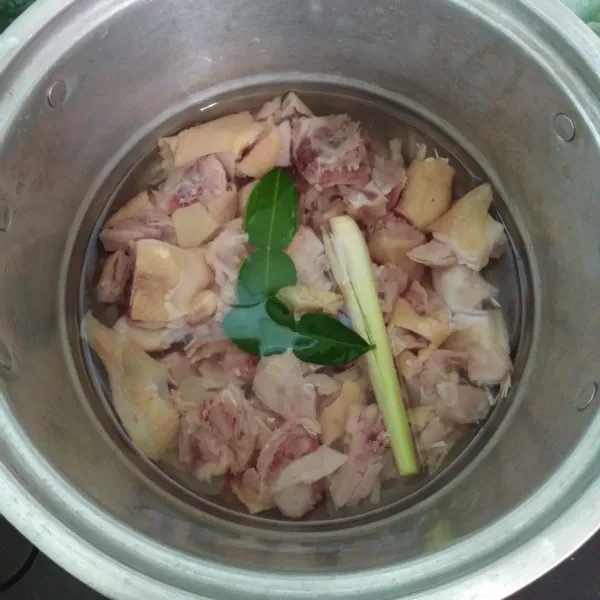 Potong-potong kecil ayam, bersihkan kemudian rebus, tambahkan daun jeruk purut dan serai kemudian rebus hingga masak lalu tiriskan.