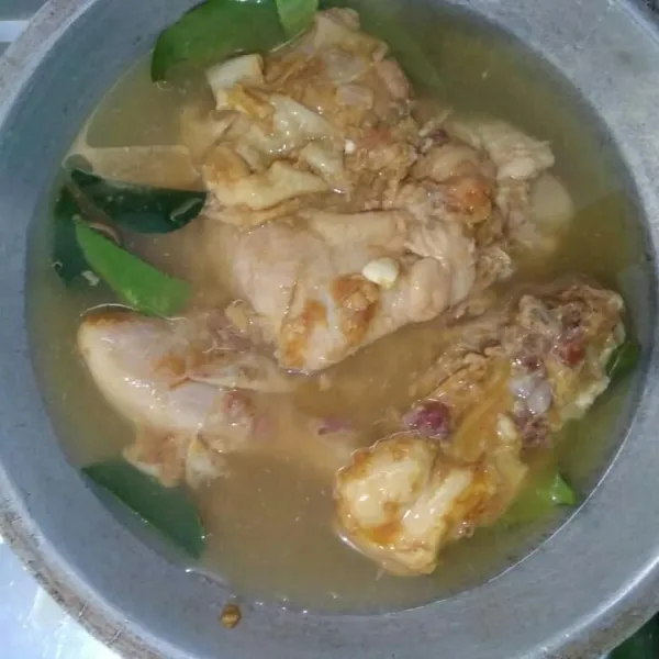 Siapkan wajan, masukkan daun salam dan daun jeruk di dasar wajan, kemudian masukkan ayam dan secukupnya air. Masak sampai kuah hampir menyusut.