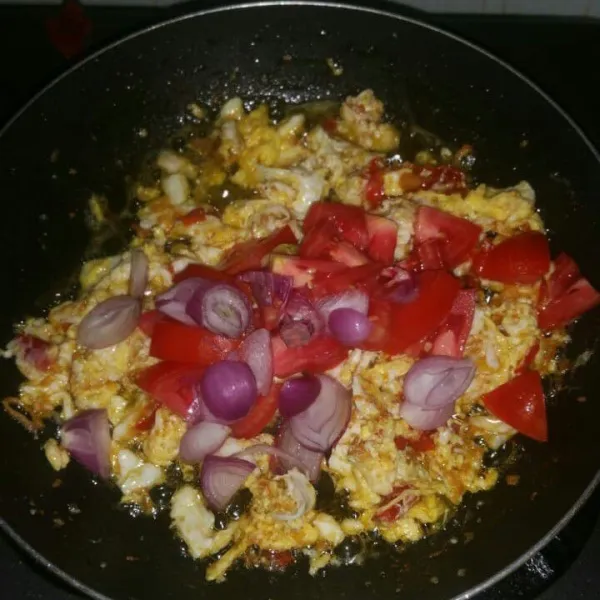 Masukan irisan tomat dan sisa bawang merah pada telur, aduk rata. Masak sampai tomat layu. Jika pada step ini minyak terasa asat, bisa di tambah lagi minyak goreng.