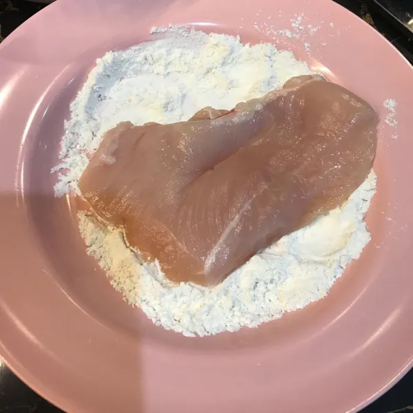 Balur ayam ke dalam tepung terigu.