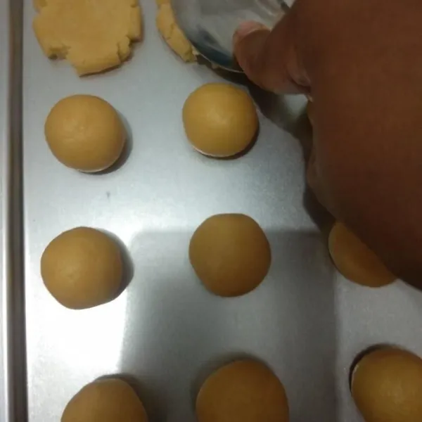 Ambil sedikit adonan, bulatkan, lalu tekan dengan sendok hingga pipih.