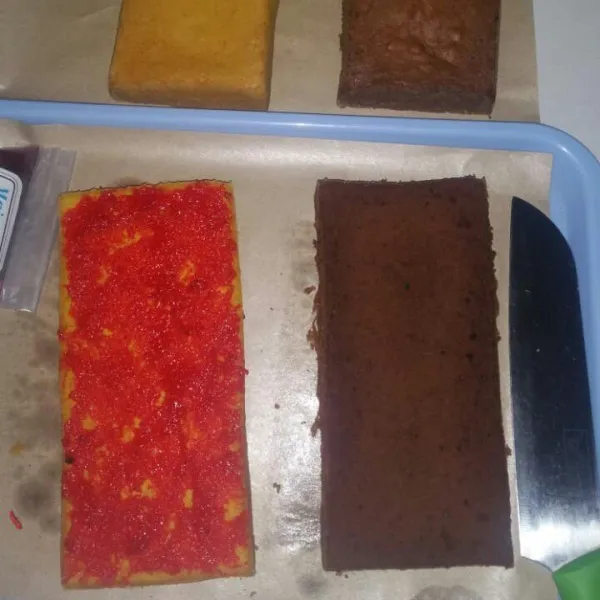 Setelah dingin belah roti menjadi 2 lalu oles salah satu bagian dengan selai strawberi, lalu tumpuk kembali dengan belahan roti yang satunya (kalau saya warna di tukar jadi kuning coklat).