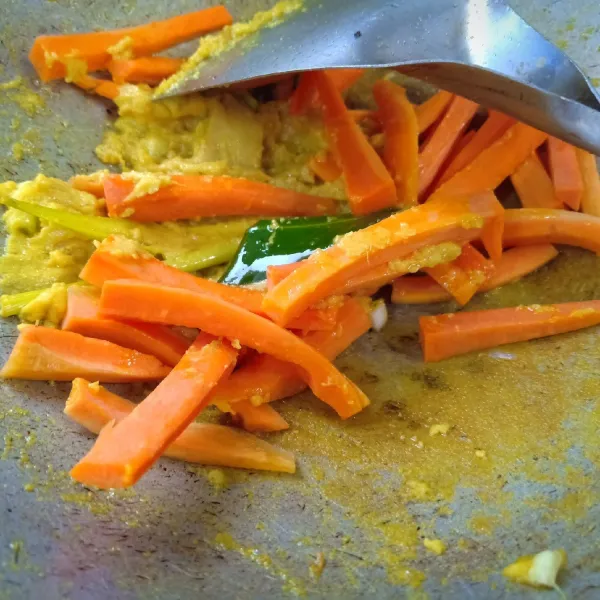 Setelah tanak atau bumbunya matang dan mengering, masukkan wortel. Tumis hingga setengah matang.