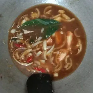 Masukkan saus tiram dan kecap manis, tumis sebentar, lalu masukkan air, daun salam, lengkuas, dan tomat. Masak hingga mendidih.