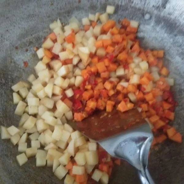 Masukkan wortel, oseng sampai wortel setengah matang kemudian masukkan kentang. Masak sampai matang.