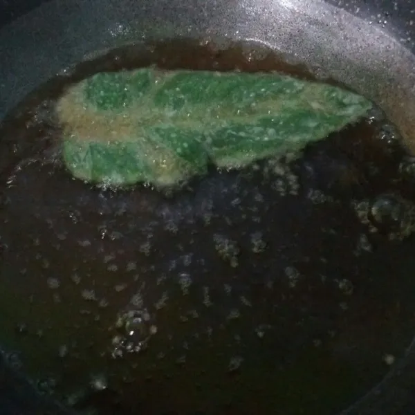 Selanjutnya goreng dalam minyak panas menggunakan api sedang. Goreng hingga matang dan garing. Lakukan hingga semua daun bayam habis digoreng.