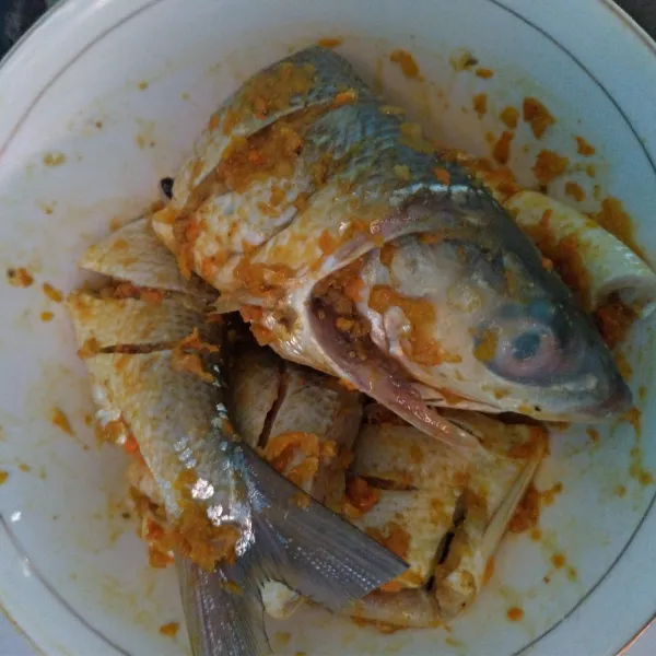 Balurkan bumbu halus pada seluruh bagian ikan, biarkan kurang lebih 30 menit sampai bumbu meresap.