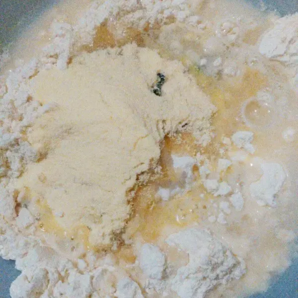 Masukkan tepung terigu, gula pasir, ragi instan, pasta pandan, dan air hangat ke dalam mangkok. Kemudian mixer hingga tercampur rata.
