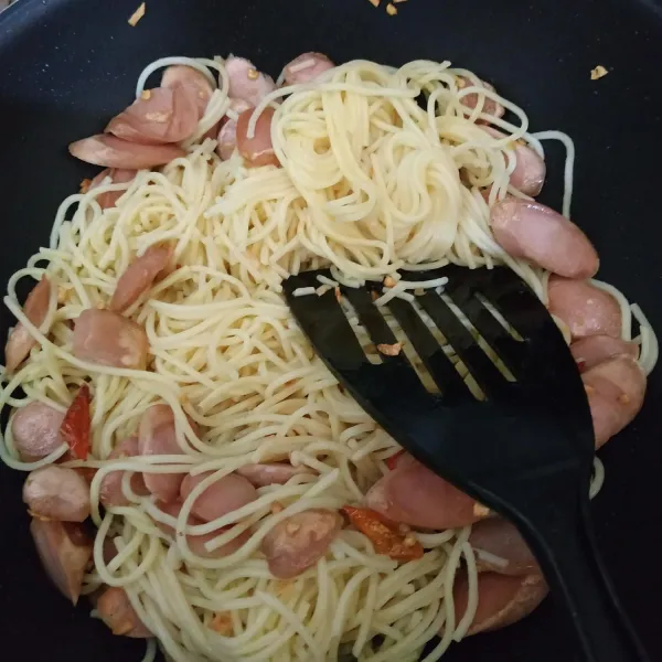 Tambahkan spaghetti yang sudah direbus, masukkan kaldu jamur, aduk rata.