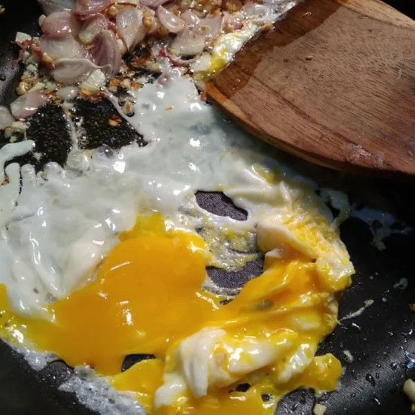 Ceplok telur ke sisi wajan yang kosong kemudian buat orak arik sebentar.