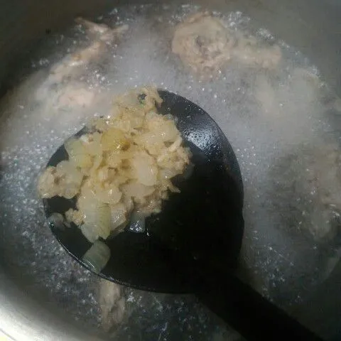 Masukkan tumisan bumbu ke dalam rebusan tulang ayam, aduk rata.