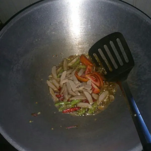 Siapkan wajan dan panaskan minyak. Tumis bawang putih dan bawang merah sampai harum, lalu masukkan cabe merah, cabe rawit, sosis ayam, dan tomat. Tumis sampai tomat sedikit layu.