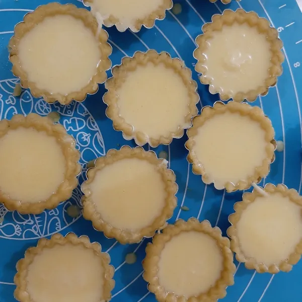 Tusuk-tusuk bagian bawah kulit pie, lalu masukkan bahan isian ke kulit pie.