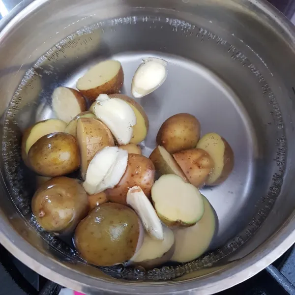 Didihkan air dalam panci kemudian masukkan kentang, bawang putih geprek, dan secukupnya garam. Masak hingga kentang empuk.