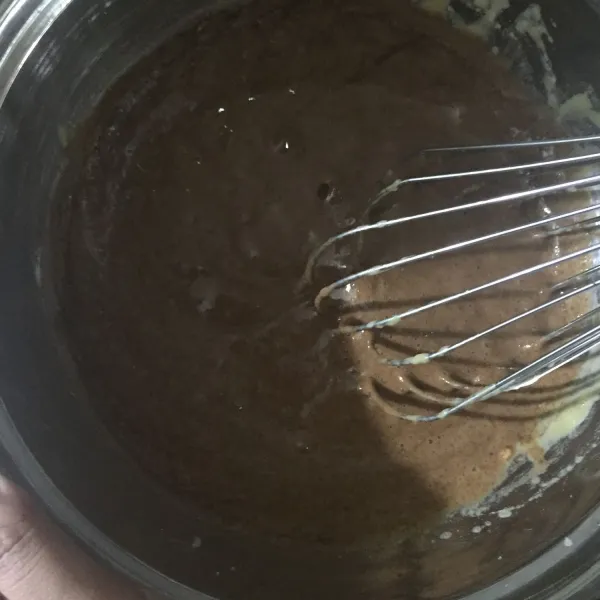 Masukkan tepung terigu dan coklat bubuk ke dalam adonan, aduk hingga tercampur rata.
