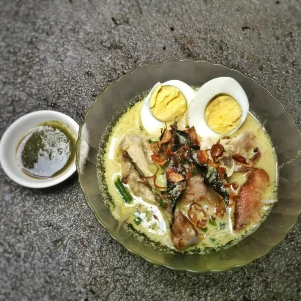 Tata bihun, tauge dan suiran ayam di dalam mangkuk. Siram kuah soto, sajikan soto bersama sambal rawit, kecap dan telur rebus.