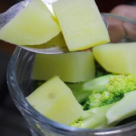 Susun kentang dan brokoli di mangkuk kecil kemudian tambahkan saus putih dan beri keju cheddar diatasnya.