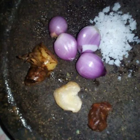 Haluskan bawang merah, kemiri, asem, dan garam, lalu geprek laos.