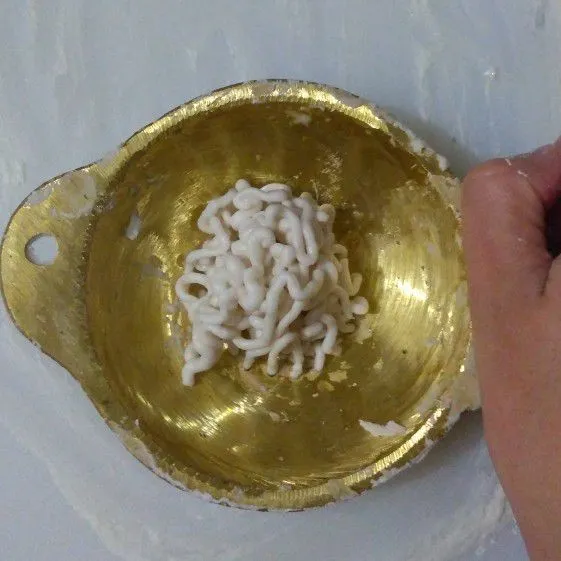 Tuangkan adonan secukupnya ke atasan talenan, lalu cetak adonan menggunakan piringan kuningan.