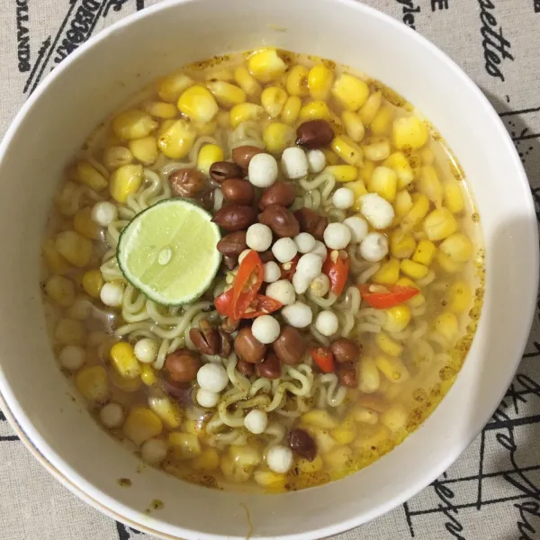 Atur mie dan jagung ke dalam mangkok, lalu siram dengan kaldu ayam, beri topping sesuai selera.