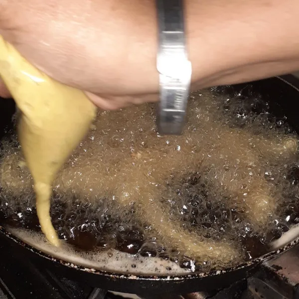 Panaskan minyak, masukkan adonan ke dalam plastik, beri lubang sedikit di ujung plastiknya. Kemudian masukkan spuit ke dalam minyak panas bentuk uler.