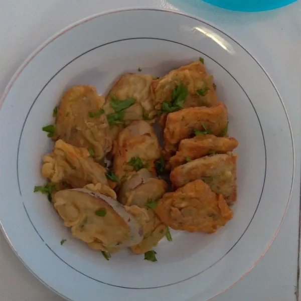 Terong tempe kriuk siap disajikan dengan irisan daun sop.