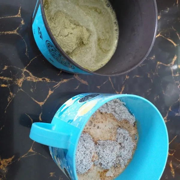 Seduh matcha dan cappucino dalam gelas yang berbeda dengan 2 sdm air panas.