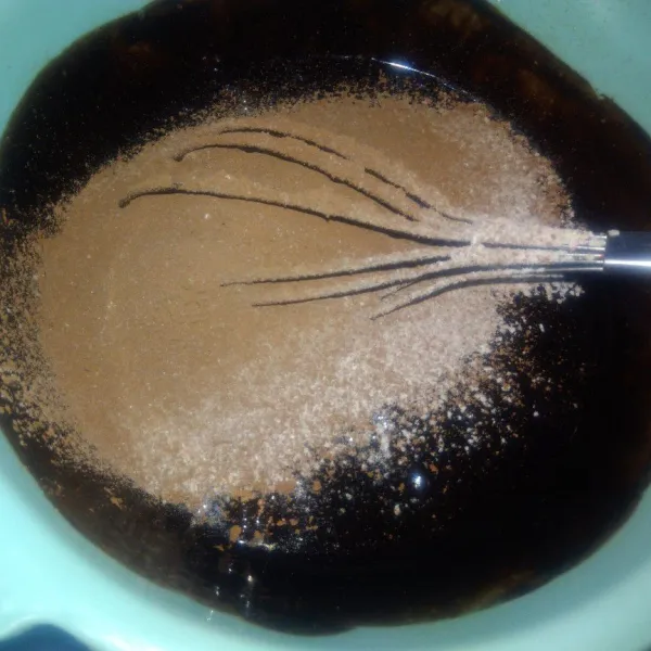 Tambahkan tepung, coklat bubuk dan vanili yang sudah di ayak ke dalam adonan coklat, aduk hingga rata.