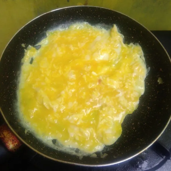 Tuang telur ke dalam teflon, aduk-aduk perlahan dan masak dengan api yang sangat kecil.
