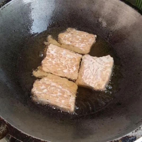 Panaskan minyak di wajan, lalu goreng tempe sampai matang.