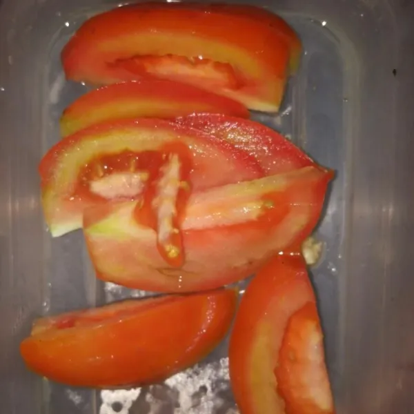 Bersihkan tomat, tempe, dan bumbu-bumbu yang diperlukan. Potong tomat menjadi beberapa bagian dan potong tempe dengan ukuran dadu. Iris bawang bombay dan geprek lengkuas.