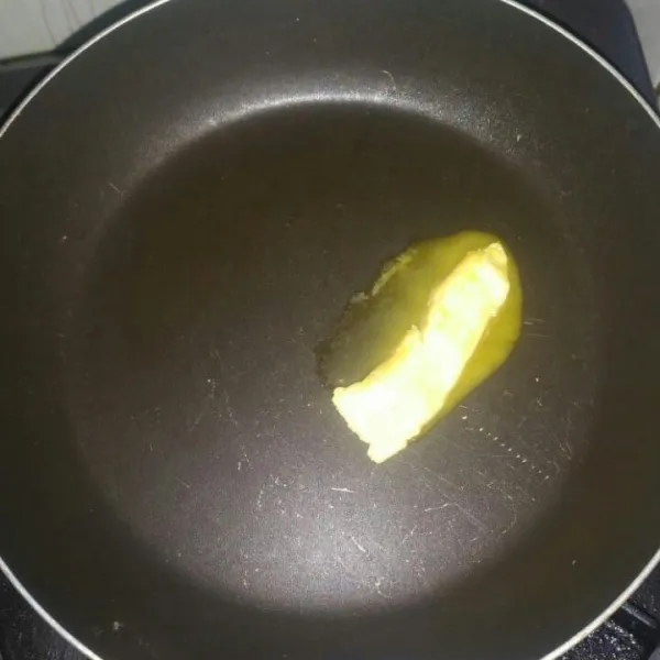 Siapkan teflon, lelehkan margarin. Ratakan ke seluruh permukaan teflon.