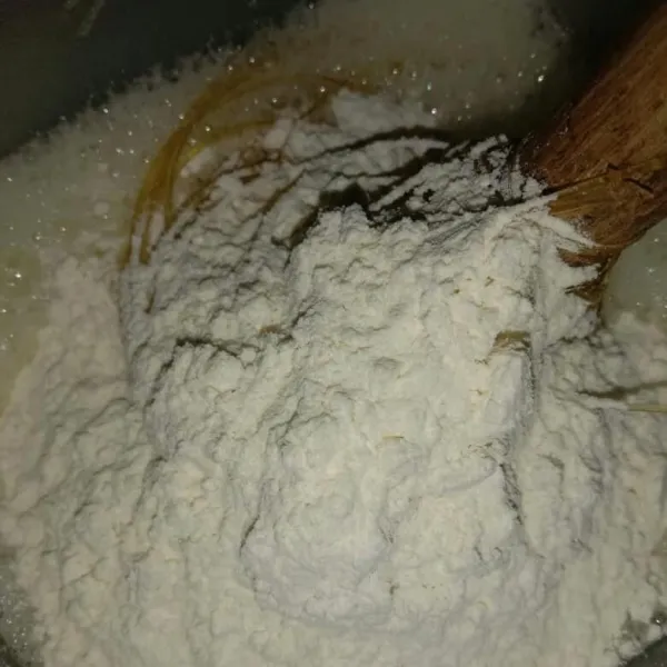 Kemudian masukkan tepung dan soda kue, aduk hingga tercampur rata.