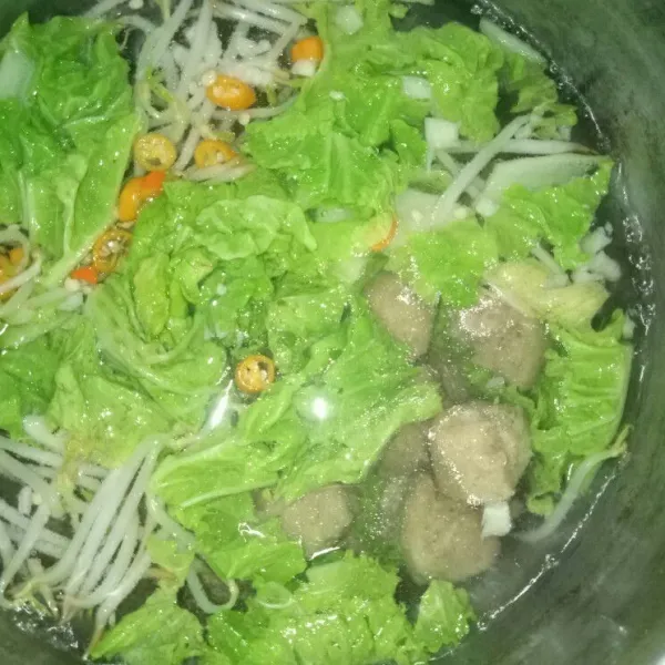 Masukkan bakso ke dalam air, tunggu sekitar 1 menit kemudian masukkan mie instan ke dalam rebusan air selama kurang lebih 2 menit.