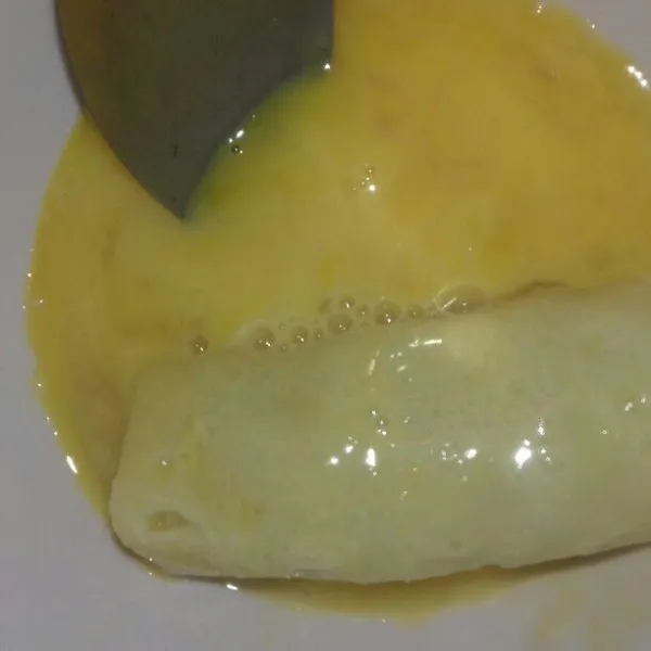 Celupkan gulungan lumpia ke dalam telur.