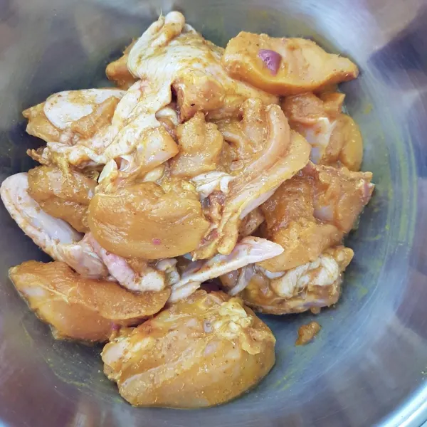 Siapkan wadah, masukkan potongan daging ayam, bawang putih bubuk, merica bubuk, ketumbar bubuk, kunyit bubuk, garam, dan kaldu jamur bubuk. Aduk rata dan simpan di lemari es semalaman atau minimal selama 1 jam.