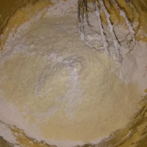 Ayak tepung terigu, tepung maizena, dan susu bubuk. Masukkan ke dalam adonan telur lalu aduk hingga rata.