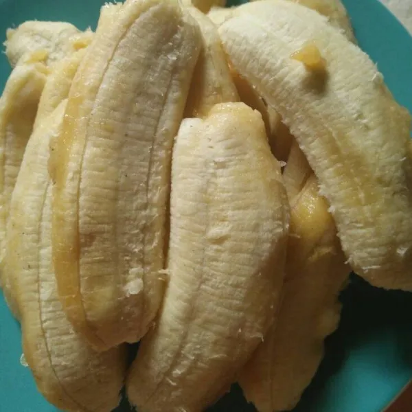 Potong pisang jadi 2 bagian.